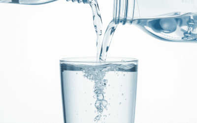 A tiszta víz közeli felvétele, ahogy egy műanyag palackból egy pohárba öntik, apró lebegő részecskék szimbolizálva a mikroplasztikokat, egy tiszta,...